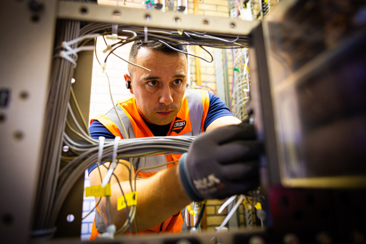 Een medewerker van seinwezen aan het werk in een relaishuis