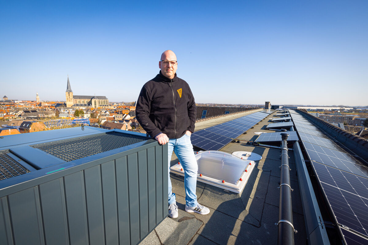 Een medewerker van een installatiebedrijf bij diverse technische installaties op het dak van een pand in Kampen