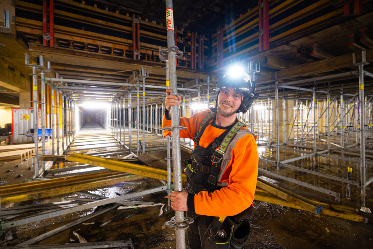 Een steigerbouwer is druk bezig met verwijderen van steigers bij de bouw van de reizigerstunnel op station Groningen