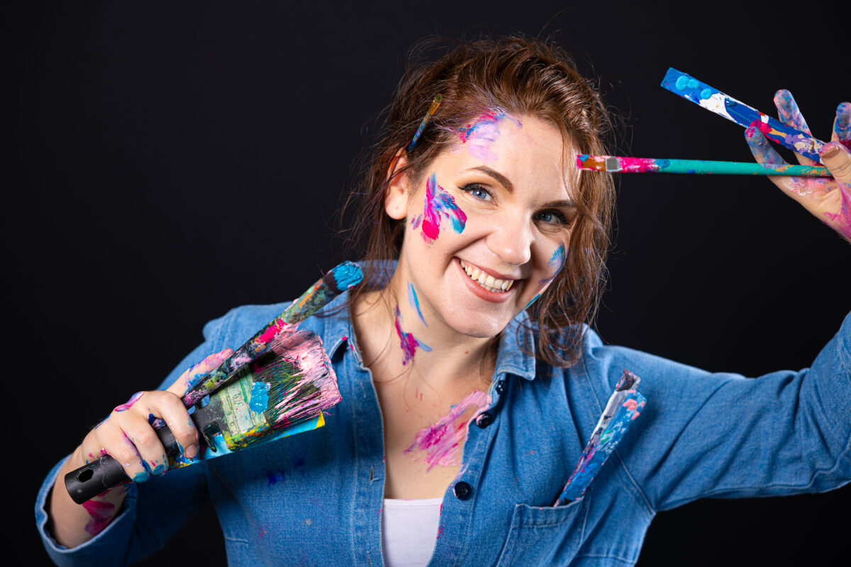 Een 3D street artist met haar werkgerei op de foto voor op de achterkant van haar werkbus