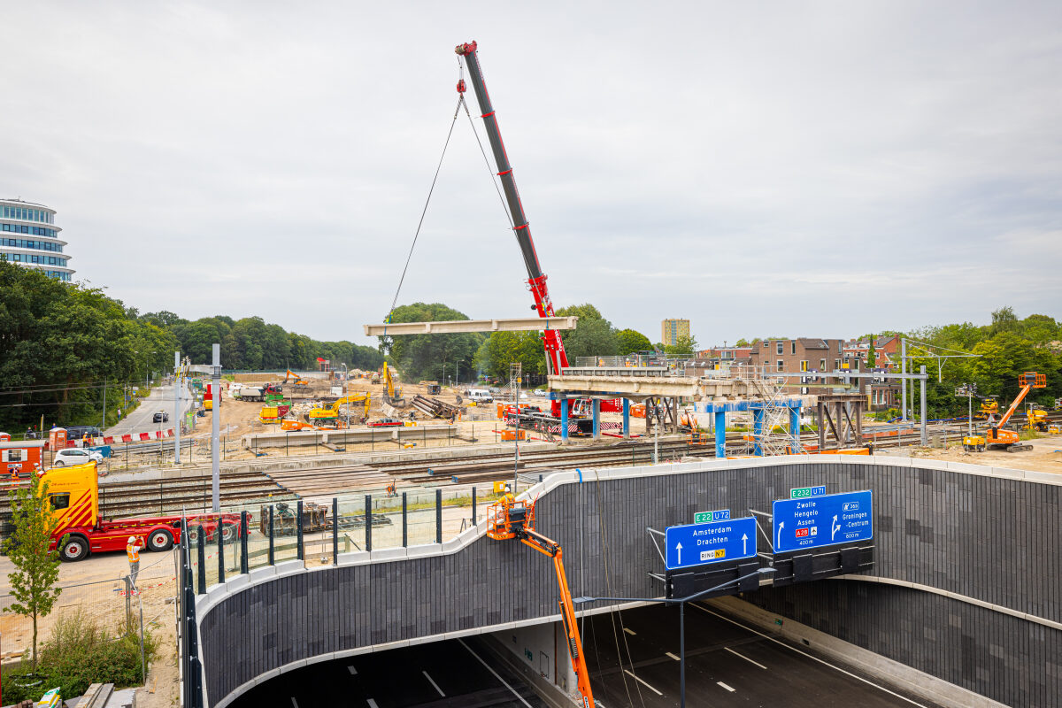 De laatste liggers van de 'oude' N7 in Groningen die over het spoor lagen worden uitgehesen met onder in de foto de nieuwe verdiepte ligging