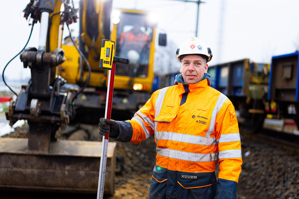 Een landmeter bij een spoorvernieuwing tussen Hoogeveen en Assen