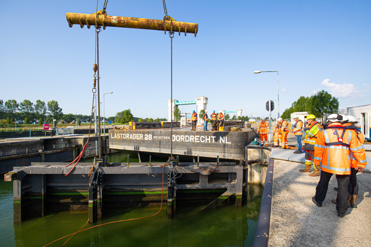 Het verwijderen van een sluisdeur bij het sluizencomplex bij Lith