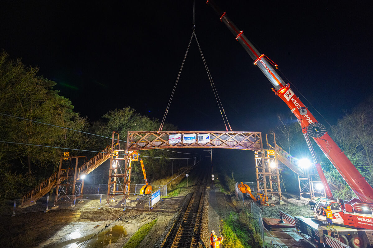 Het inhijsen van de loopbrug over het spoor bij Vilsteren