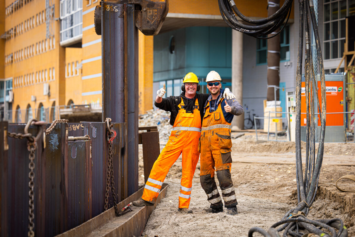 Twee bouwvakkers bij de bouw van de bustunnel bij station Groningen