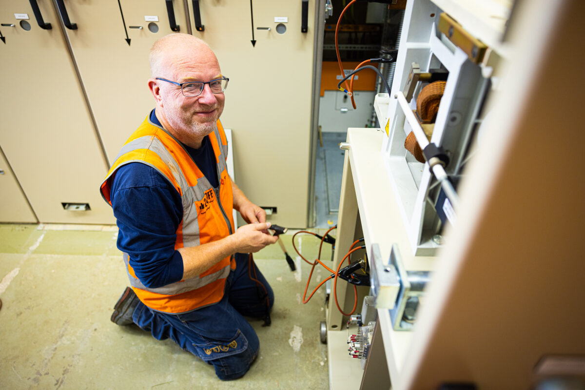 Een medewerker energievoorziening van een spooraannemer aan het werk bij een onderstation tussen De Lutte (NL) en Bad Bentheim (D)