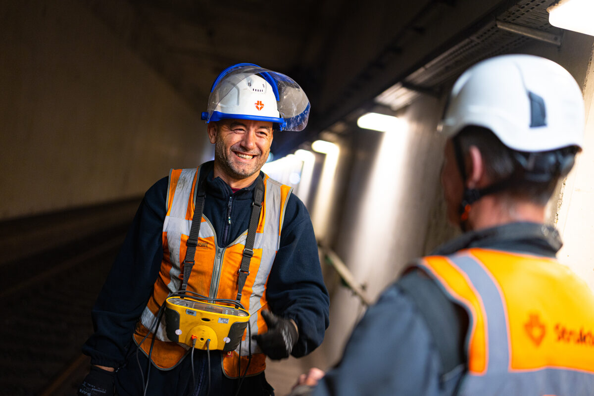 Een spoorwerker in gesprek met zijn collega bij werkzaamheden in de spoortunnel van Delft
