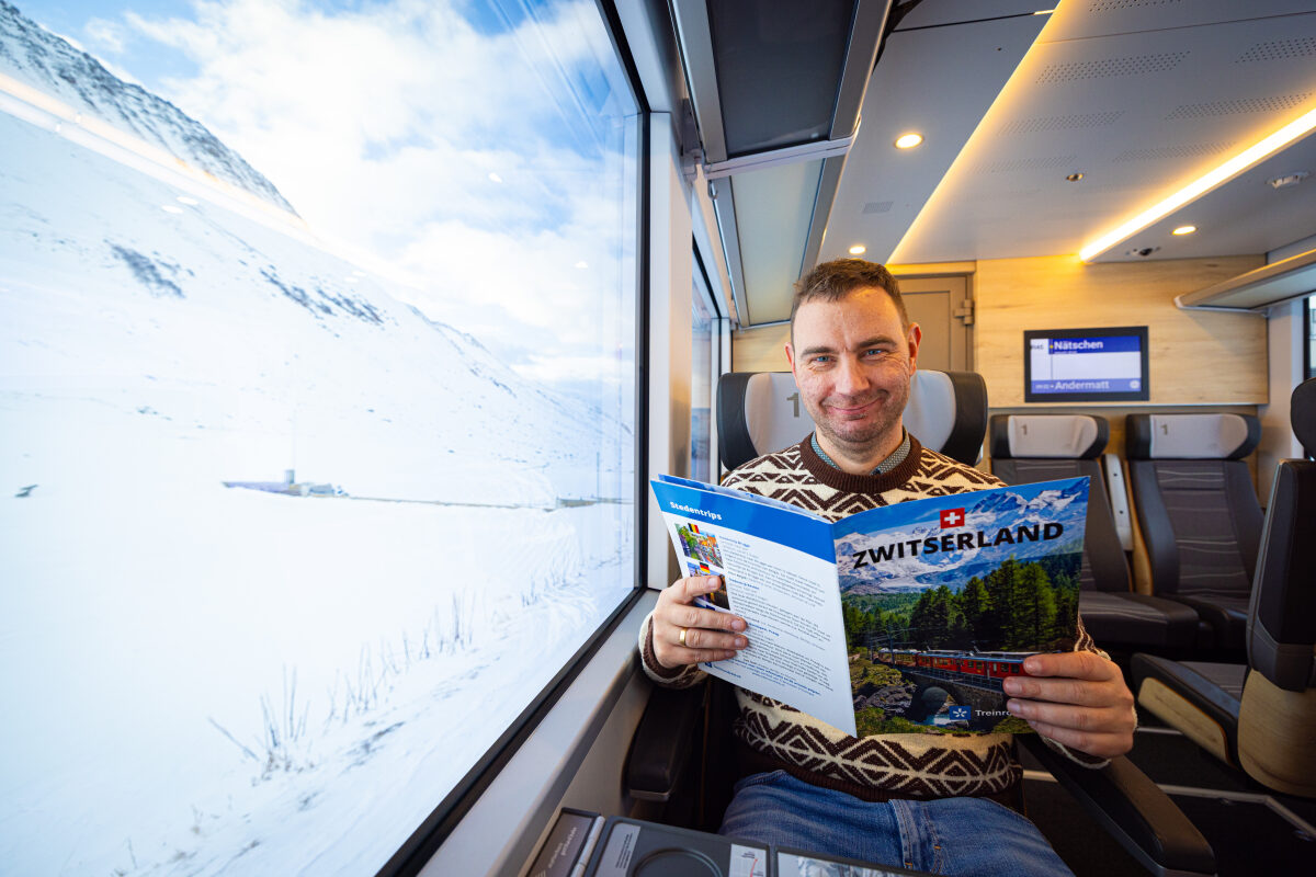 De eigenaar van een winkel voor treinrondreizen op de foto in de trein in de Zwitserse Alpen
