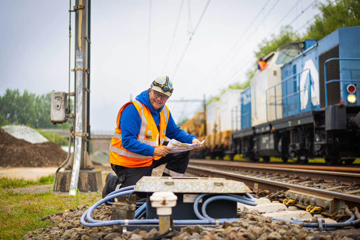 Een medewerker van een spooraannemer aan het werk bij een sectiescheiding op het spoor