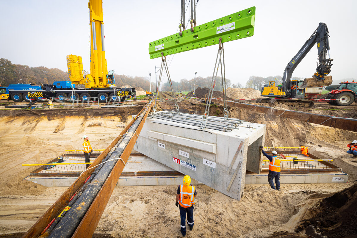 Het inhijsen van een tunnelelement voor een veetunnel onder het spoor bij Dalfsen