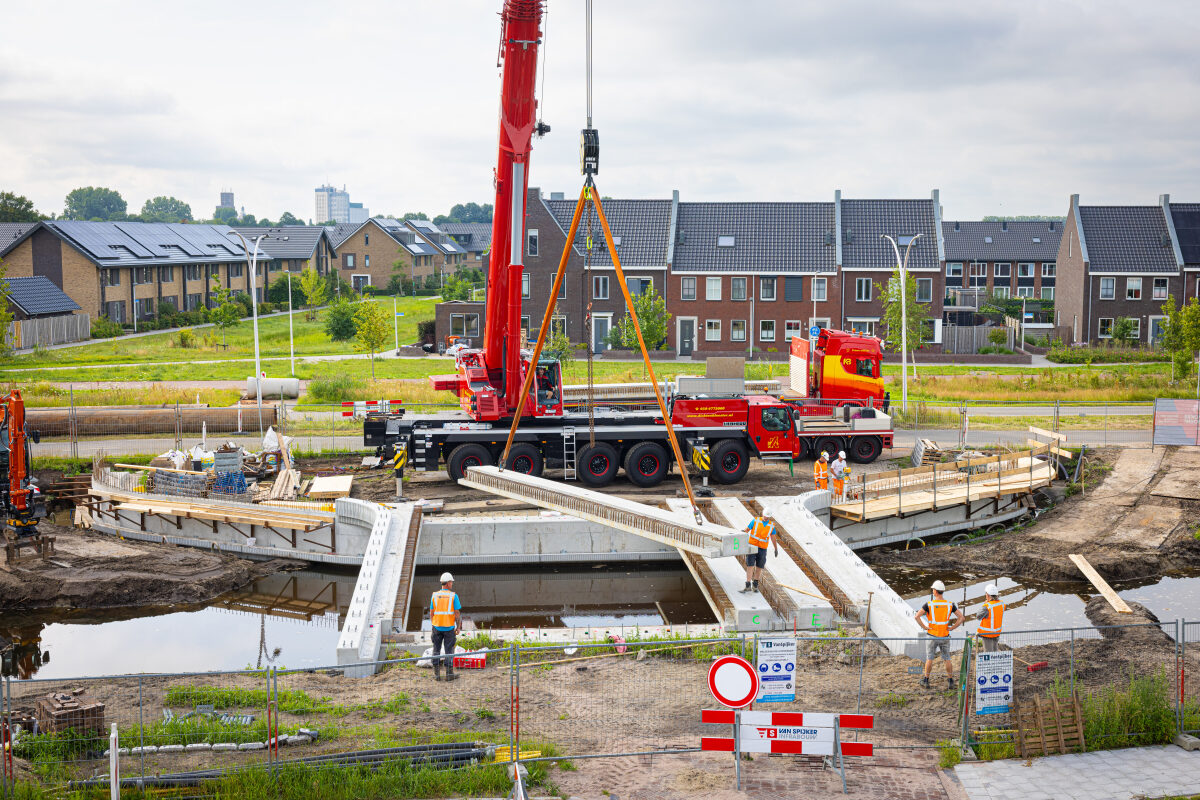 Het inhijsen van een ligger voor een nieuwe brug in de nieuwbouwwijk Nieuwveense Landen in Meppel